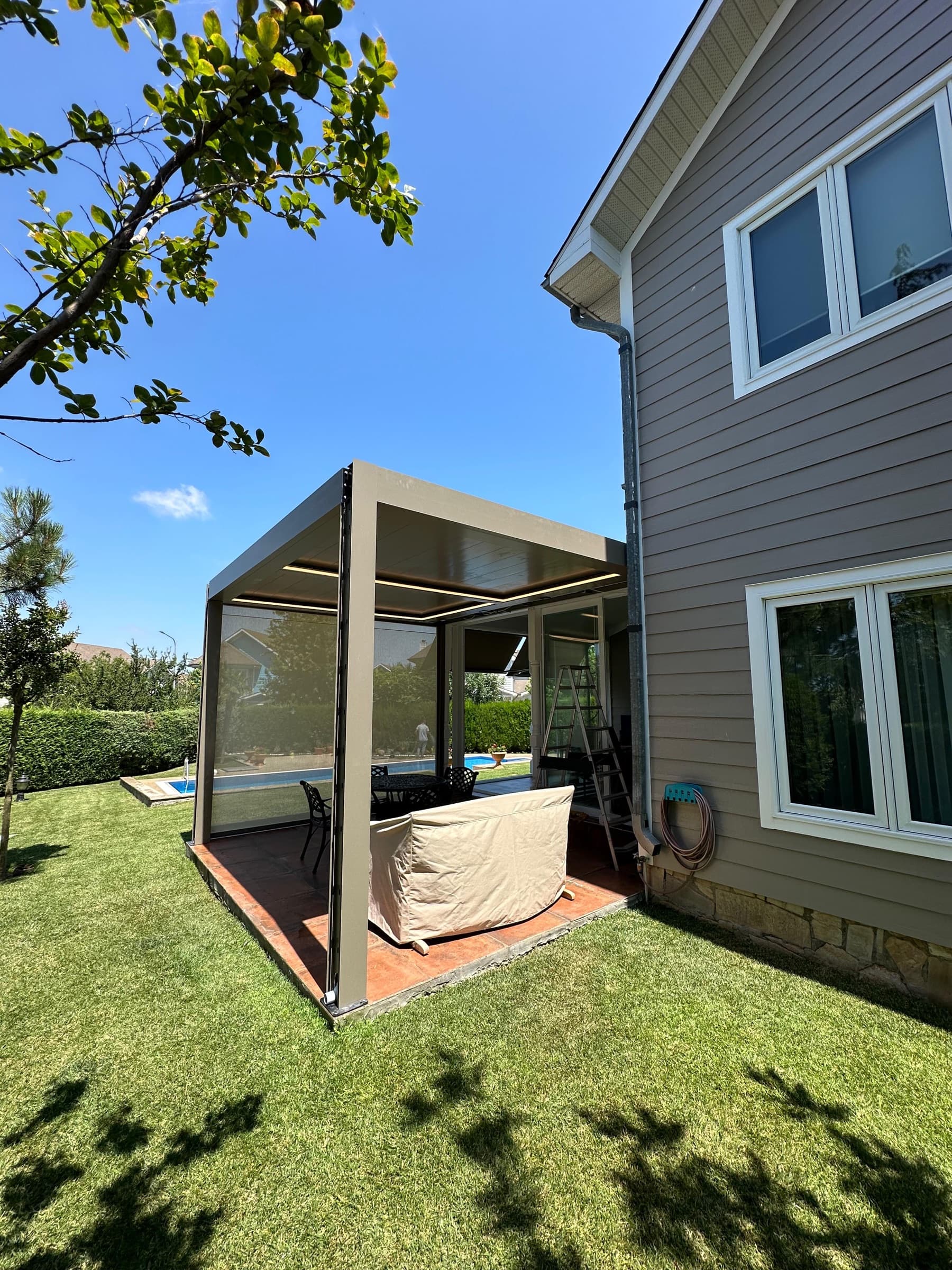Havuzlu villa bahçesinde uygulanmış bioklimatik pergola